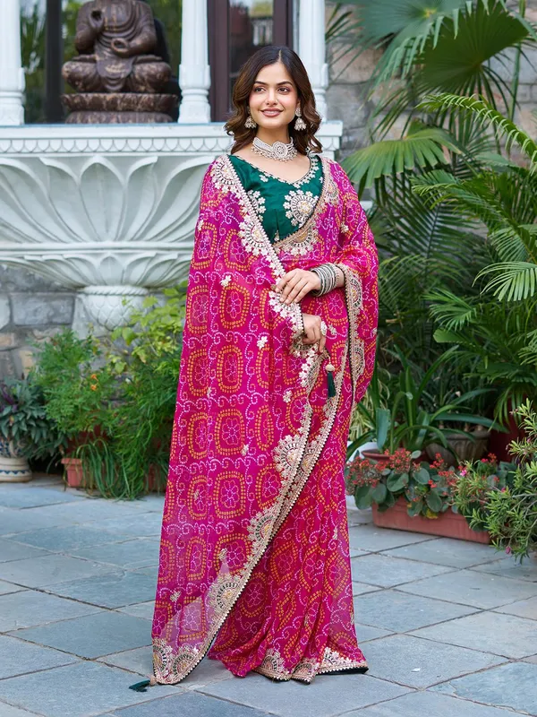 Pink_Bandhani_Saree_With_Heavy_Embellished_Border_And_Green_Embroidered_Blouse