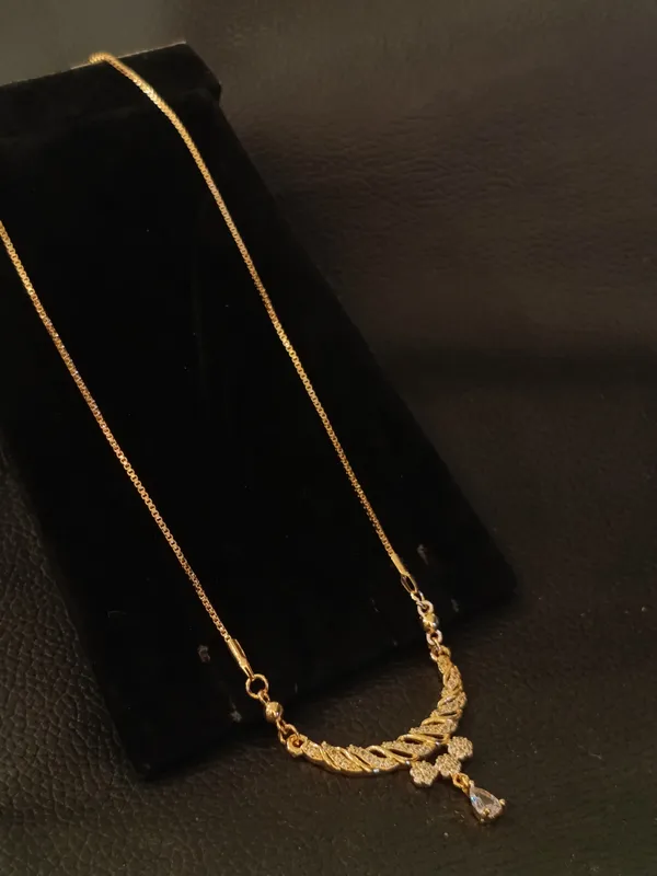 Elegant_Gold_Toned_Necklace_With_Curved_Pendant_And_Crystal_Drop