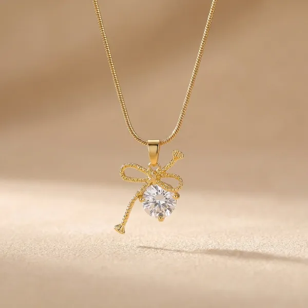 Gold_Toned_Brass_Ribbon_Bow_Pendant_Necklace_With_Clear_Crystal_Stone