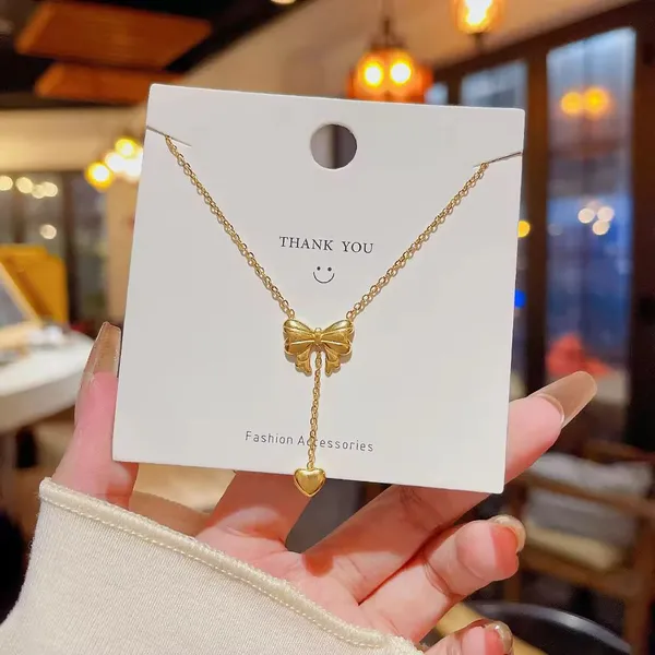 Elegant_Gold_Bow_Pendant_Necklace_with_Heart_Drop_Charm