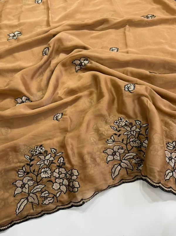 RIDHI_SAREE_✨_Premium_Soft_Chiffon_Saree_✨__Grace_your_look_with_this_elegant_golden_beige_organza_saree_featuring_beautiful_floral_embroidery_work_with_a_stylish_black_outline_border._The_lightweight_and_soft_fabric_gives_a_rich,_classy,_and_graceful_appearance,_perfect_for_festive_occasions,_parties,_weddings,_and_special_events._Paired_with_a_matching_black_embroidered_blouse_piece,_this_saree_creates_a_stunning_traditional_yet_modern_look._
