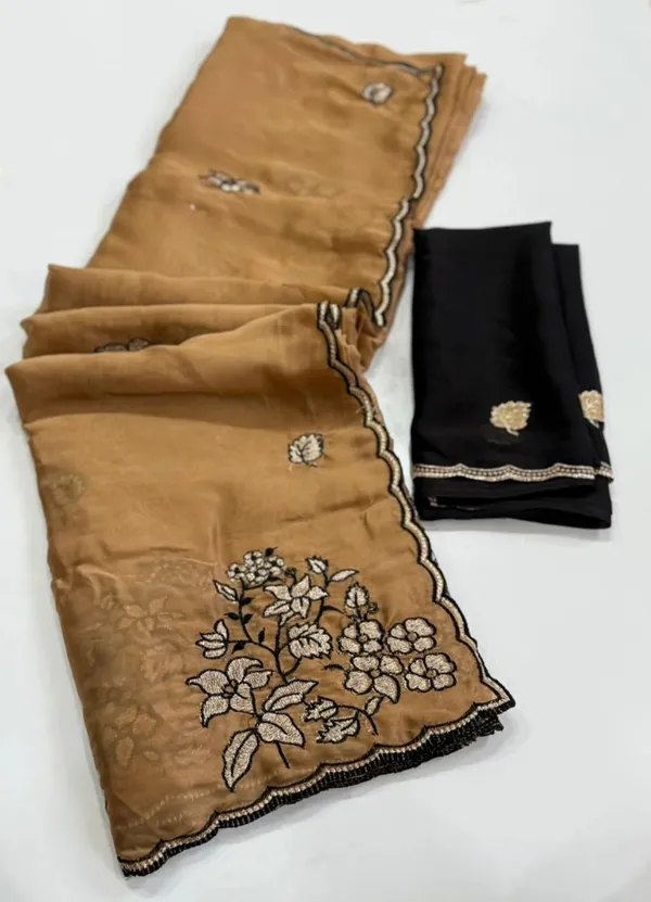 RIDHI_SAREE_✨_Premium_Soft_Chiffon_Saree_✨__Grace_your_look_with_this_elegant_golden_beige_organza_saree_featuring_beautiful_floral_embroidery_work_with_a_stylish_black_outline_border._The_lightweight_and_soft_fabric_gives_a_rich,_classy,_and_graceful_appearance,_perfect_for_festive_occasions,_parties,_weddings,_and_special_events._Paired_with_a_matching_black_embroidered_blouse_piece,_this_saree_creates_a_stunning_traditional_yet_modern_look._