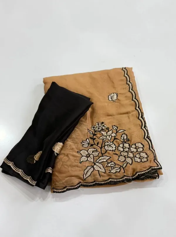 RIDHI_SAREE_✨_Premium_Soft_Chiffon_Saree_✨__Grace_your_look_with_this_elegant_golden_beige_organza_saree_featuring_beautiful_floral_embroidery_work_with_a_stylish_black_outline_border._The_lightweight_and_soft_fabric_gives_a_rich,_classy,_and_graceful_appearance,_perfect_for_festive_occasions,_parties,_weddings,_and_special_events._Paired_with_a_matching_black_embroidered_blouse_piece,_this_saree_creates_a_stunning_traditional_yet_modern_look._