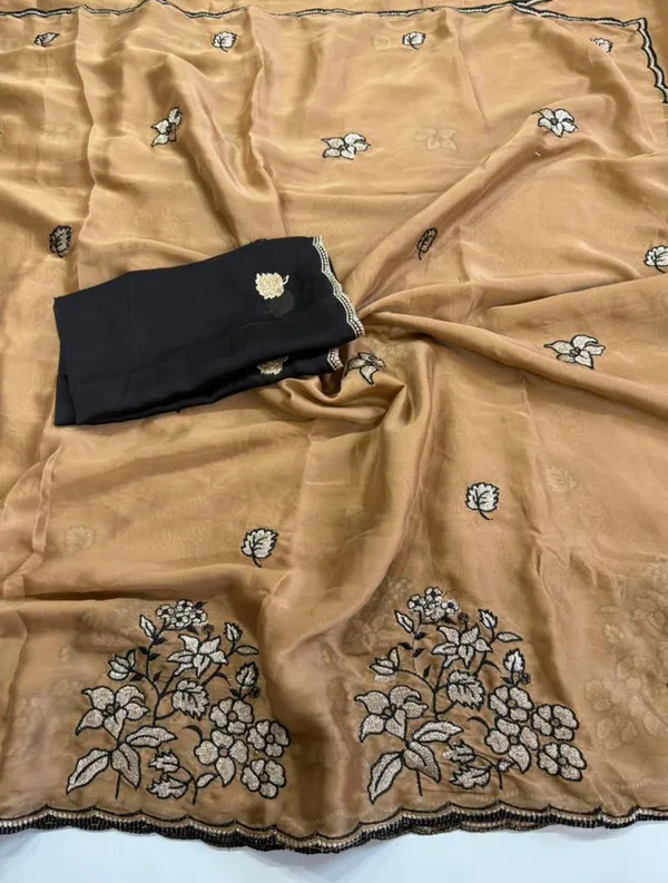 RIDHI_SAREE_✨_Premium_Soft_Chiffon_Saree_✨__Grace_your_look_with_this_elegant_golden_beige_organza_saree_featuring_beautiful_floral_embroidery_work_with_a_stylish_black_outline_border._The_lightweight_and_soft_fabric_gives_a_rich,_classy,_and_graceful_appearance,_perfect_for_festive_occasions,_parties,_weddings,_and_special_events._Paired_with_a_matching_black_embroidered_blouse_piece,_this_saree_creates_a_stunning_traditional_yet_modern_look._