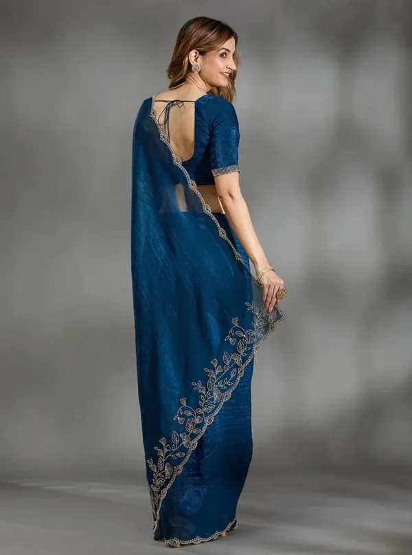 Elevate_your_ethnic_wardrobe_with_this_stunning_Navy_Blue_Designer_Saree_crafted_for_timeless_elegance._Featuring_delicate_floral_embroidery_work_on_the_border_and_pallu,_this_saree_blends_grace_with_modern_sophistication._The_rich_texture_and_shimmering_finish_add_a_luxurious_charm,_making_it_perfect_for_weddings,_festive_occasions,_parties,_and_special_celebrations._Paired_with_a_stylish_matching_blouse,_this_saree_gives_a_classy_and_graceful_look_effortlessly._
