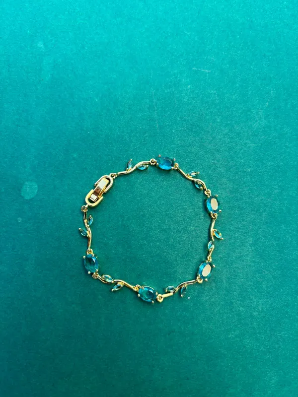 Gold-Tone_Bracelet_With_Blue_Oval_Gemstones