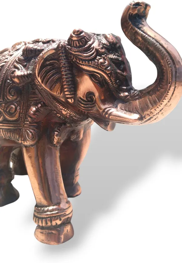 This_is_a_copper‑finished_decorative_statue_of_an_elephant_with_intricate_engraved_patterns_on_its_body,_head,_and_legs._The_craftsmanship_shows_detailed_filigree_work_and_an_antique,_regal_appearance,_making_it_a_stylish_décor_piece_for_display_or_gifting_-_9_INCH