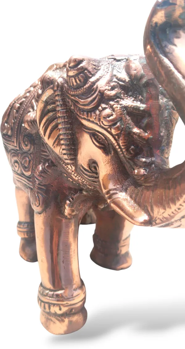 This_is_a_copper‑finished_decorative_statue_of_an_elephant_with_intricate_engraved_patterns_on_its_body,_head,_and_legs._The_craftsmanship_shows_detailed_filigree_work_and_an_antique,_regal_appearance,_making_it_a_stylish_décor_piece_for_display_or_gifting_-_9_INCH