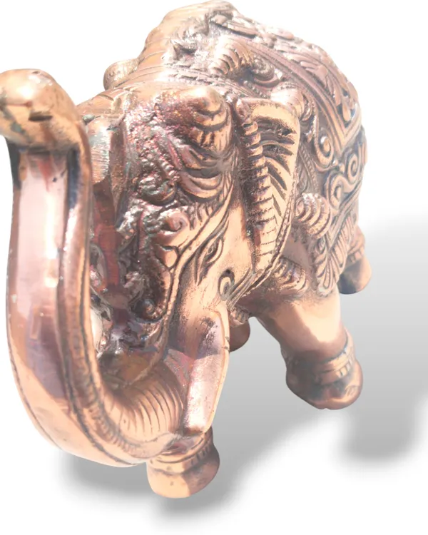 This_is_a_copper‑finished_decorative_statue_of_an_elephant_with_intricate_engraved_patterns_on_its_body,_head,_and_legs._The_craftsmanship_shows_detailed_filigree_work_and_an_antique,_regal_appearance,_making_it_a_stylish_décor_piece_for_display_or_gifting_-_9_INCH