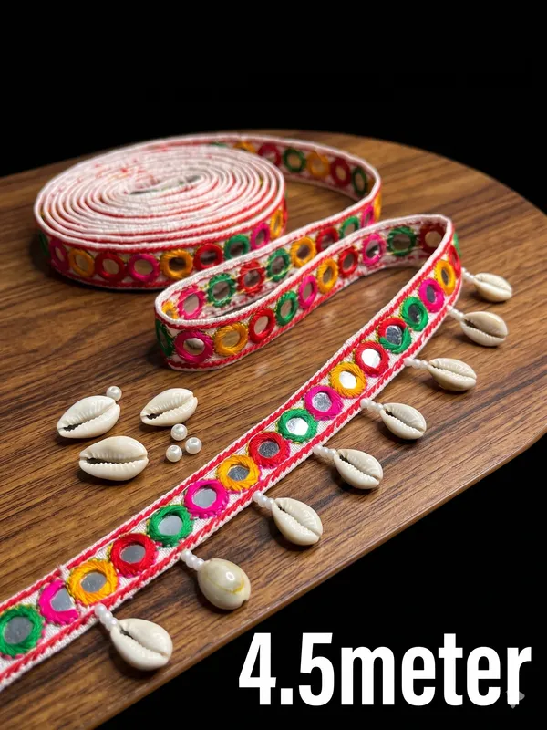 Bring_traditional_bohemian_charm_and_Real_shell_vibrant_folk_aesthetics_to_your_collection_with_this_exquisite_Multicolored_and_Real_Cowrie_Shell_Lace_Trim._Expertly_crafted_with_a_structured_white_fabric_base_featuring_colorful_embroidered_thread_rings_inset_with_tiny_mirrors,_this_statement_border_is_finished_with_dangling_natural_cowrie_shells_for_a_striking_ethnic_appeal.