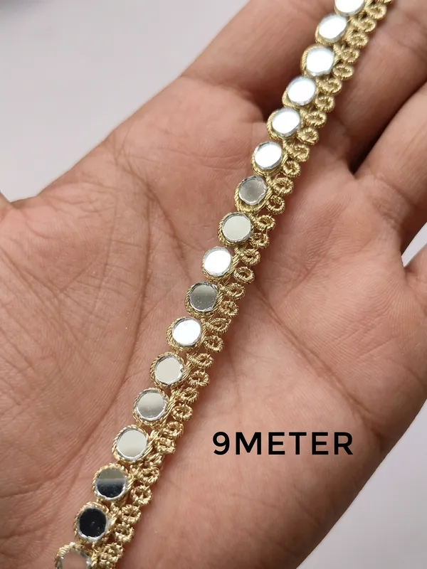 Dazzle_with_traditional_elegance_using_this_stunning_9-meter_gold_zari_lace,_intricately_embellished_with_shimmering_mirror-work_trim._Designed_to_catch_the_light_from_every_angle,_this_versatile_9-meter_border_adds_an_instant_touch_of_festive_glamour_and_royal_flair_to_your_sarees,_lehengas,_kurtis,_and_creative_craft_projects.