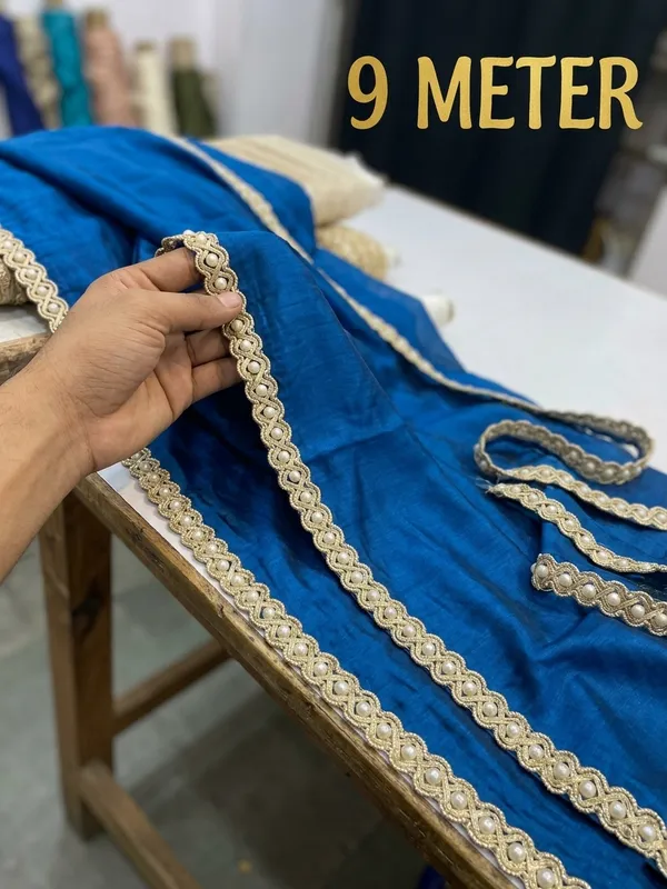 Elevate_your_ethnic_creations_with_this_magnificent_9-meter_lace_border,_intricately_braided_with_rich_golden_threads_and_studded_with_lustrous_pearls._Designed_to_add_royal_charm_to_sarees,_lehengas,_and_dupattas,_this_premium_trim_brings_timeless_elegance_and_sophisticated_flair_to_your_favorite_traditional_garments.