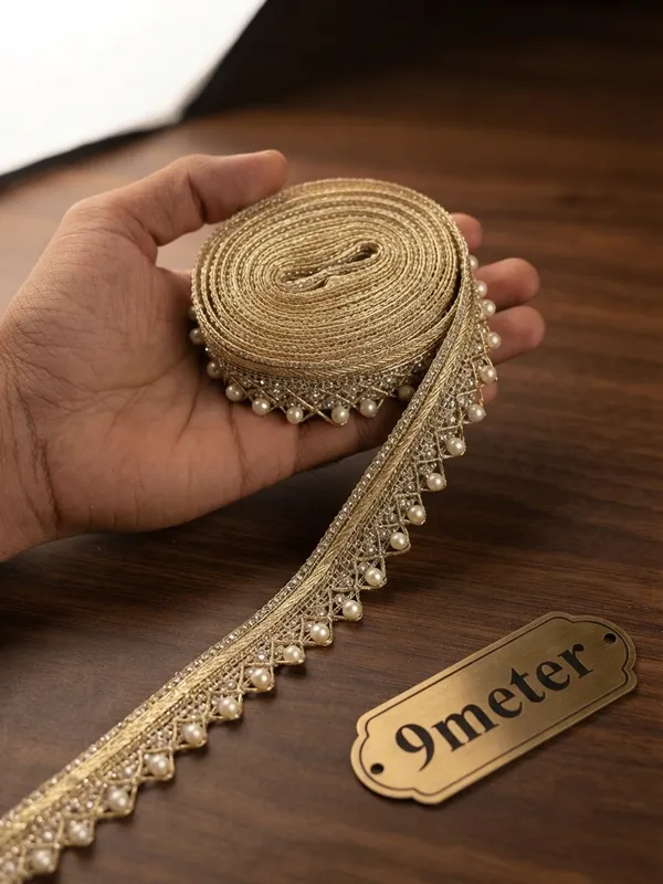 Enhance_your_ethnic_wear_and_designer_collections_with_this_exquisite_Metallic_Gold_and_Pearl_Beaded_Lace_Trim._Beautifully_crafted_with_a_structured,_shimmering_gold_woven_header_and_detailed_geometric_lattice_work,_this_designer_border_is_finished_with_a_charming_row_of_dangling_white_pearl_drops_for_an_opulent_touch.