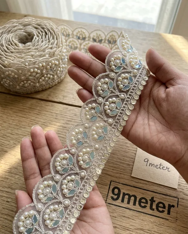 Infuse_your_ethnic_collections_with_royal_elegance_using_this_magnificent_Scalloped_Pearl_and_Mirror_Lace_Trim._Expertly_crafted_with_a_wide,_ornate_mesh_base_featuring_intricate_scalloped_arches_filled_with_floral-inspired_pearl_clusters_and_reflective_mirror_inserts,_this_designer_border_delivers_breathtaking_grandeur_to_high-end_apparel.