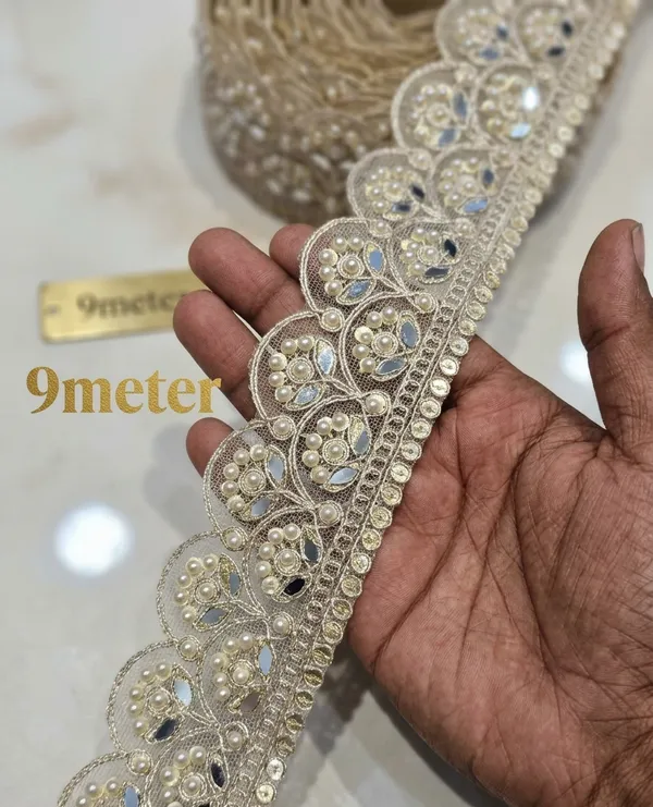 Infuse_your_ethnic_collections_with_royal_elegance_using_this_magnificent_Scalloped_Pearl_and_Mirror_Lace_Trim._Expertly_crafted_with_a_wide,_ornate_mesh_base_featuring_intricate_scalloped_arches_filled_with_floral-inspired_pearl_clusters_and_reflective_mirror_inserts,_this_designer_border_delivers_breathtaking_grandeur_to_high-end_apparel.