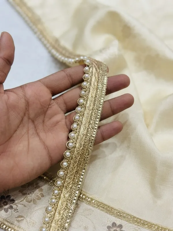 Upgrade_your_ethnic_and_couture_collections_with_this_sophisticated_Multi-Band_Gold_and_Pearl_Lace_Trim._Featuring_a_multi-layered_design_composed_of_a_shimmering_metallic_gold_braid,_a_textured_woven_center_band,_and_a_delicate_beaded_edge_lined_with_luminous_white_pearls,_this_designer_border_brings_refined_elegance_and_dimensional_richness_to_any_garment.