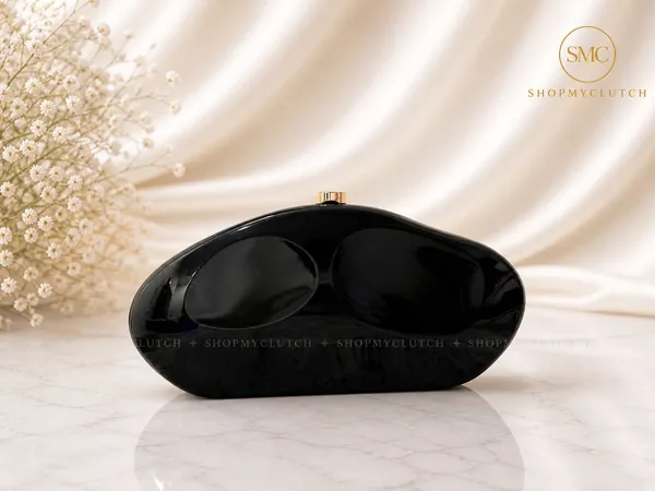 Elegant_Black_Clutch_With_Golden_Chain_And_Decorative_Brooch