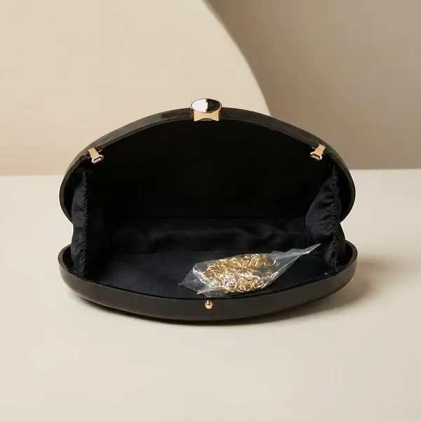 Elegant_Black_Clutch_With_Golden_Chain_And_Decorative_Brooch