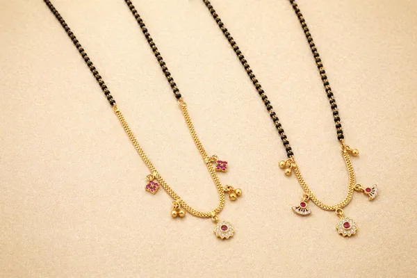 Dual-Tone_Black_And_Gold_Mangalsutra_Set_With_Pink_Stone_Floral_Pendant_And_Traditional_Black_Beaded_Mangalsutra_With_Golden_Pendant_Charms_(Pack_Of_2)