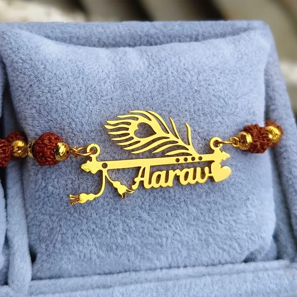 Personalized_Name_Rakhi_with_Flute_&_Peacock_Feather_Design_–_Custom_Gold-Finish_Religious_Rakhi_for_Brother_PACK_OF_-_2