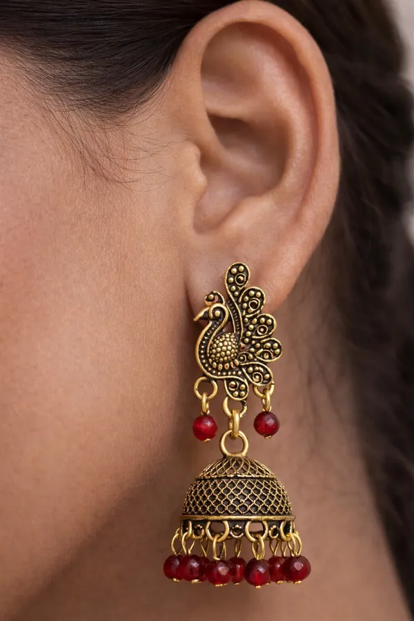 Elegant_peacock-inspired_Maroon_and_gold_jhumka_earrings_adorned_with_intricate_detailing_and_Green_bead_accents
