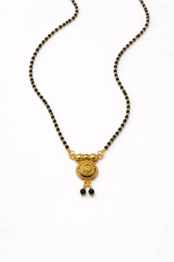 Elegant_single-chain_mangalsutra_with_black_beads_and_a_gold-toned_circular_pendant