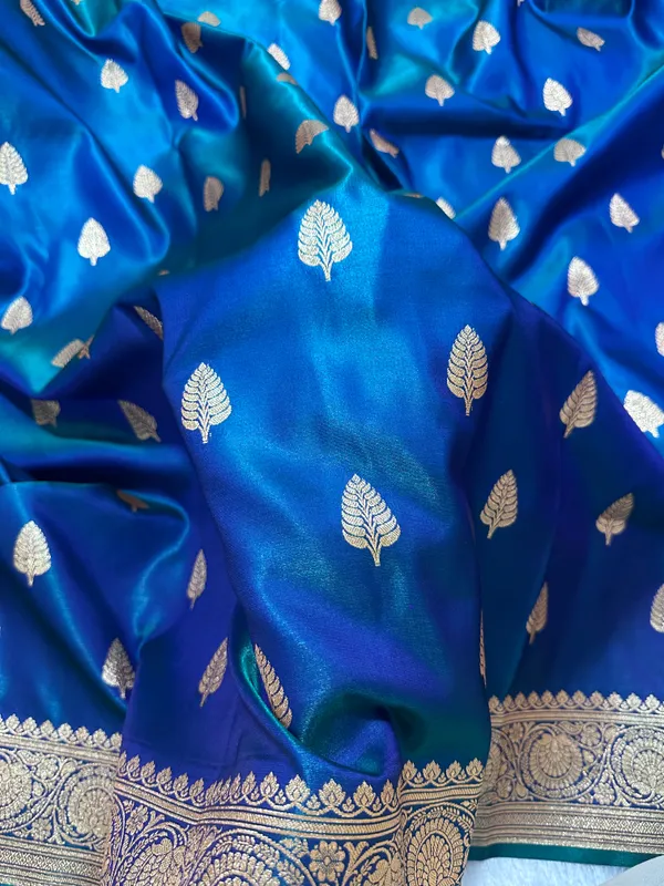 Royal_Peacock_Blue_Satin_Silk_Banarasi_Saree_With_Royal_Guldasta_Chakra_Border_And_Bold_Gold_Panna_Butis