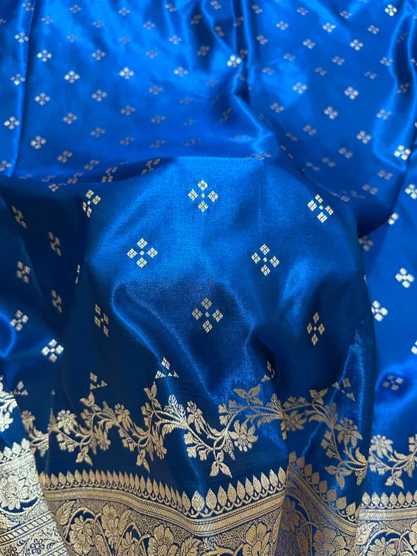Royal_Peacock_Blue_Satin_Silk_Banarasi_Saree_With_Royal_Floral_Jhallar_Border_And_Geometric_Chowk_Butis