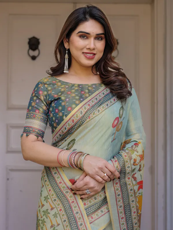 Mint_Green_Folk_Printed_Handloom_Cotton_Saree_with_Village_Scene_Panel_Pallu,_Ornamental_Border_&_Tassels_–_Traditional_Ethnic_Wear