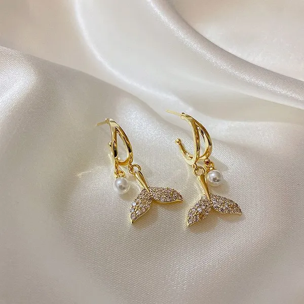 Style_elegant_gold_earrings_displayed_on_soft_white_satin_fabric