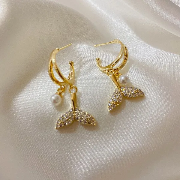 Style_elegant_gold_earrings_displayed_on_soft_white_satin_fabric