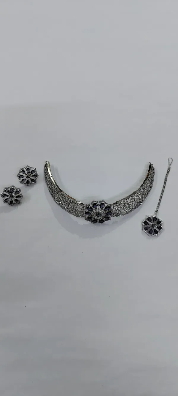 AD_Choker_Necklace_Set_with_Blue_Sapphire_Floral_Detail
Includes_Earrings_&_Tika,_Brooch-Style_Centre,_Silver_Tone_Finish,_Cubic_Zirconia