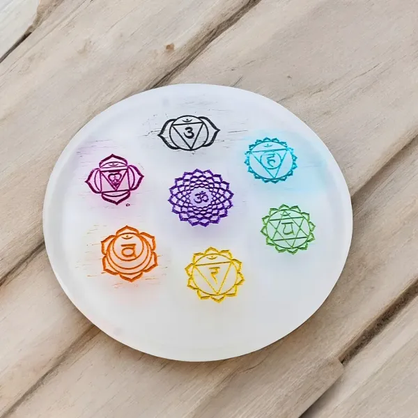 Selenite_charging_plate_features_the_seven_colorful_chakra_symbols_printed_on_its_surface_and_is_designed_for_cleansing_and_recharging_other_crystals._(3_inch)