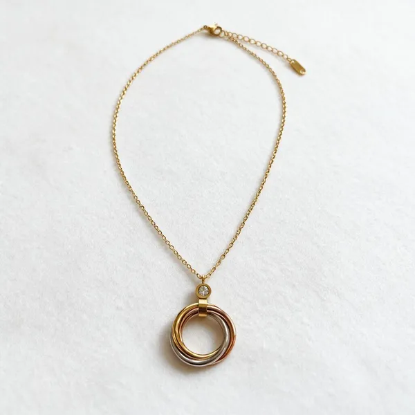 Geometric_Interlocking_Pendant_Necklace_With_Tri_Color_Bands_In_Polished_Gold,_Rose_Gold_And_Silver_Finishes_Suspended_From_A_Brilliant_Bezel_Set_Zircon_Accent