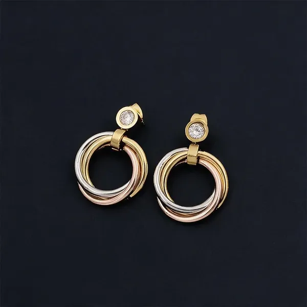 Geometric_Interlocking_Drop_Earings_With_Tri_Color_Bands_In_Polished_Gold,_Rose_Gold_And_Silver_Finishes_Suspended_From_A_Brilliant_Bezel_Set_Zircon_Accent