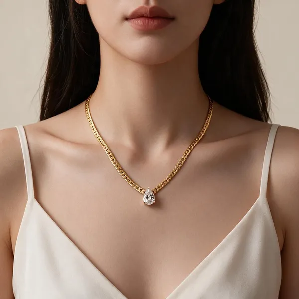 Classic_Multi_Prong_Gold_Bezel_Featuring_A_Teardrop_Gem_Suspended_Directly_From_A_Bold,_Textured_Flat_Figaro_Style_Chain_(Gold)