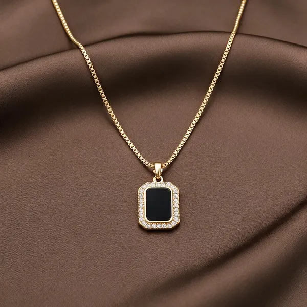 Vacation_Inspired_Pendant_Necklace_Featuring_A_Sleek,_Rectangular_Quadrilateral_Design_With_A_Deep_Black_Onyx_Style_Acrylic_Center_Framed_By_A_Shimmering_Halo_Of_Pave_Set_Cubic_Zirconia_Stones_Suspended_From_An_Elegant_Textured_Chain_(Gold)