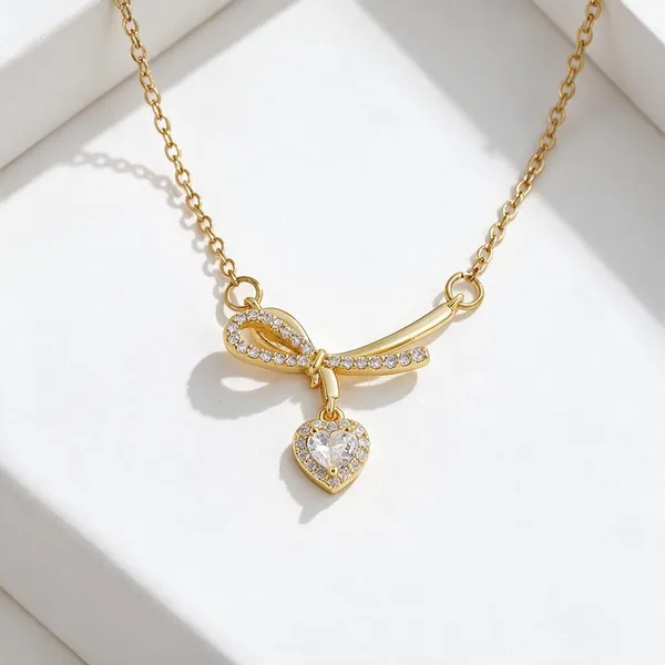 Charming_Pendant_Necklace_Featuring_An_Elegant_Ribbon_Bow_Motif_Pave_Set_With_Sparkling_Clear_Rhinestones_With_A_Dangling_Delicate_Heart_Shaped_Crystal_Charm_(Gold)