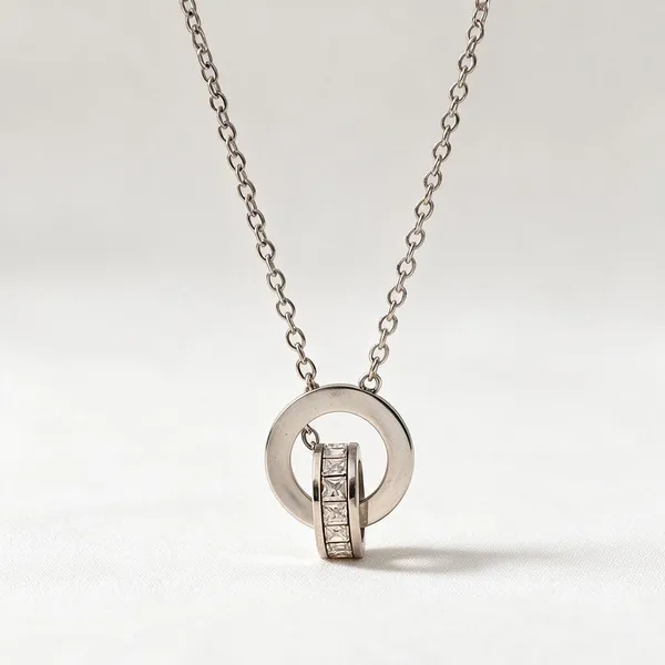 Two_Interlocking_Ring_Pendants_Necklace_With_One_Plain_Polished_Circle_Paired_With_A_Secondary_Ring_Inlaid_With_Sparkling_Micro_Pave_Cubic_Zirconia_(Silver)