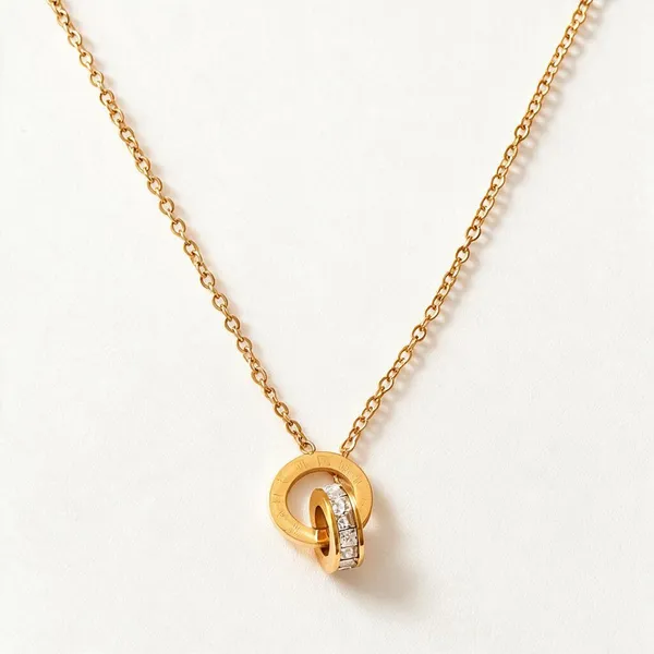 Two_Interlocking_Ring_Pendants_Necklace_With_One_Plain_Polished_Circle_Paired_With_A_Secondary_Ring_Inlaid_With_Sparkling_Micro_Pave_Cubic_Zirconia_(Gold)