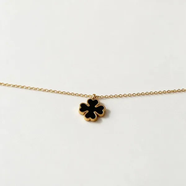 Versatile_Reversible_Iconic_Four_Leaf_Clover_Pendant_Necklace_Featuring_A_2_In_1_Design_Finished_With_A_Sleek_Black_Enamel_Inlay_On_One_Side_And_Radiant_White_Enamel_Inlay_On_The_Other_(Gold)