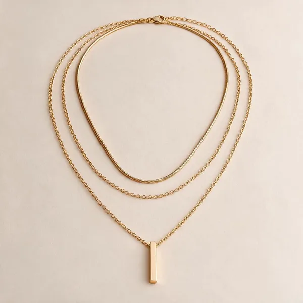 Multi_Strand_Layered_Necklace_Creating_An_Effortless_Pre_Layered_Look_Featuring_A_Flat_Snake_Chain,_A_Classic_Cable_Chain,_And_A_Longer_Link_Chain_With_A_Sleek_Vertical_Bar_Pendant_(Gold)