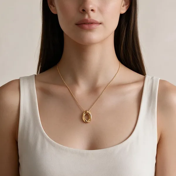 Sculptural,_Mobius_Inspired_Twisted_Oval_Motif_Ring_Pendant_Suspended_Along_A_Delicate_Cable_Chain_(Gold)