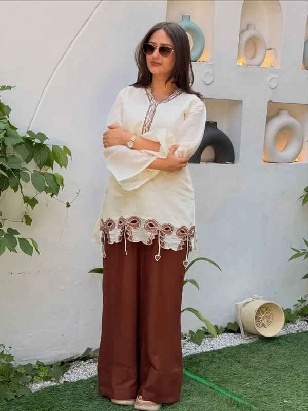 Cream_And_Brown_Bow-Detailed_Tunic_Top_Paired_With_Wide-Leg_Pink_Trousers