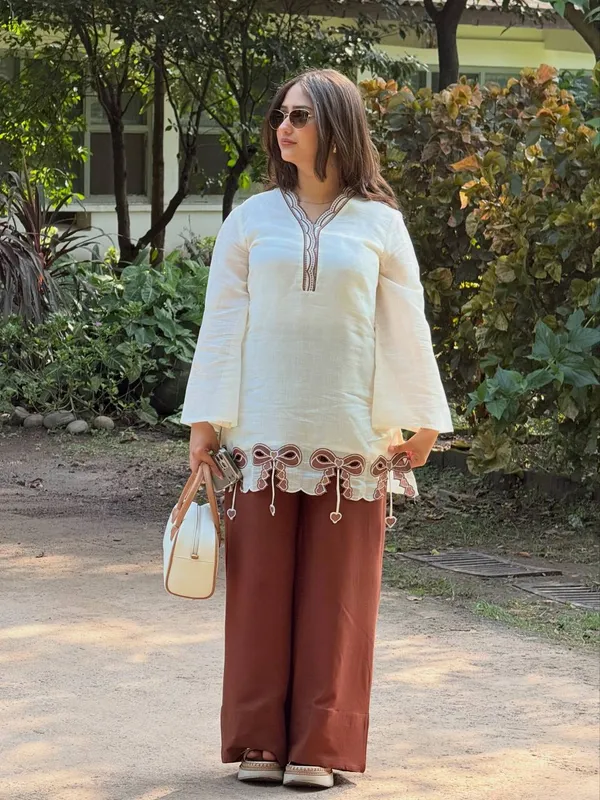 Cream_And_Brown_Bow-Detailed_Tunic_Top_Paired_With_Wide-Leg_Pink_Trousers