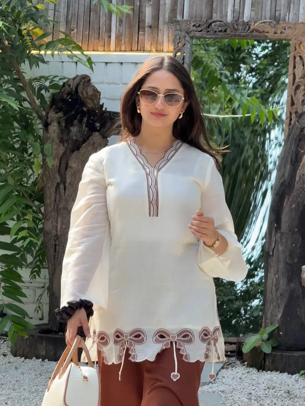 Cream_And_Brown_Bow-Detailed_Tunic_Top_Paired_With_Wide-Leg_Pink_Trousers