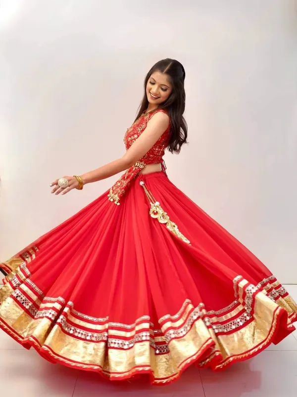 Red_And_Gold_Embellished_Chaniya_Choli_Features_Intricate_Traditional_Mirror_Work_And_Coin_Detailing_Along_The_Waist_And_Hem