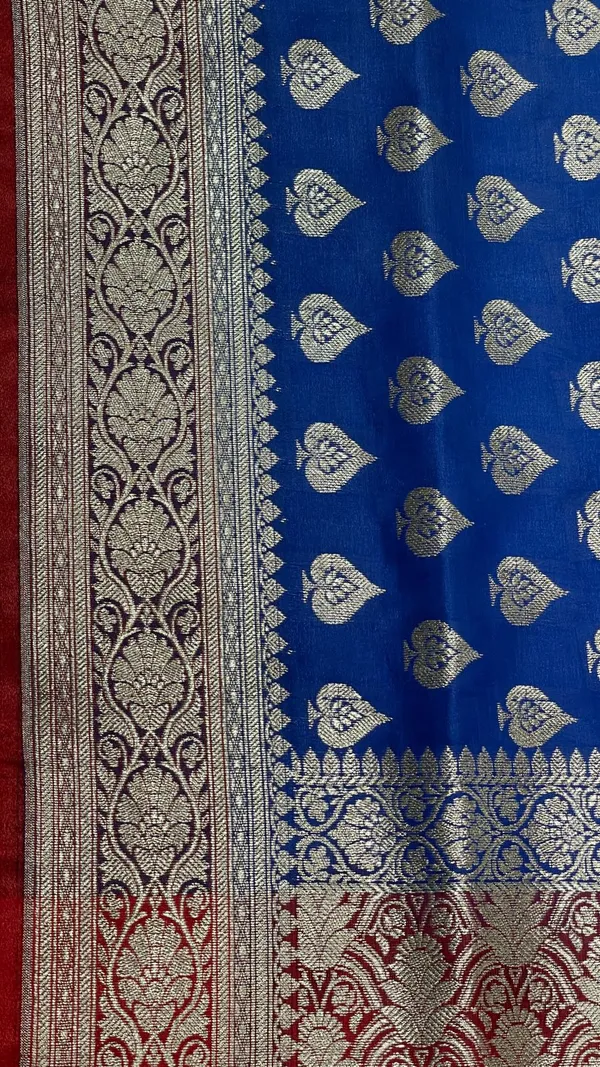 Humairah_Presents_Blue_Satin_Silk_Silver_Zari_Pan_Booti_and_Contrast_Red_Zari_Border_and_Heavy_Silver_Zari_Floral_Anchal_Banarasi_Saree_with_Red_Blouse