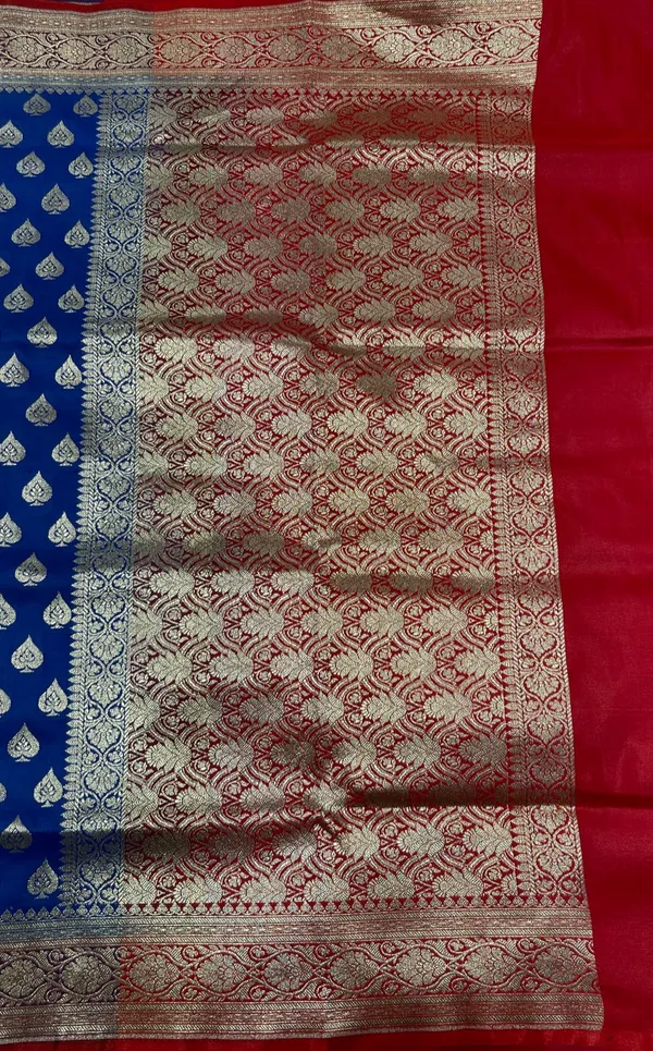 Humairah_Presents_Blue_Satin_Silk_Silver_Zari_Pan_Booti_and_Contrast_Red_Zari_Border_and_Heavy_Silver_Zari_Floral_Anchal_Banarasi_Saree_with_Red_Blouse