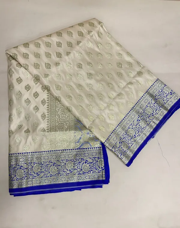 Humairah_Presents_Off-White_Katan_Silk_Floral_Light_Gold_Zari_Booti_with_Contrast_Blue_Floral_Pallu_Banarasi_saree_and_Blue_Blouse